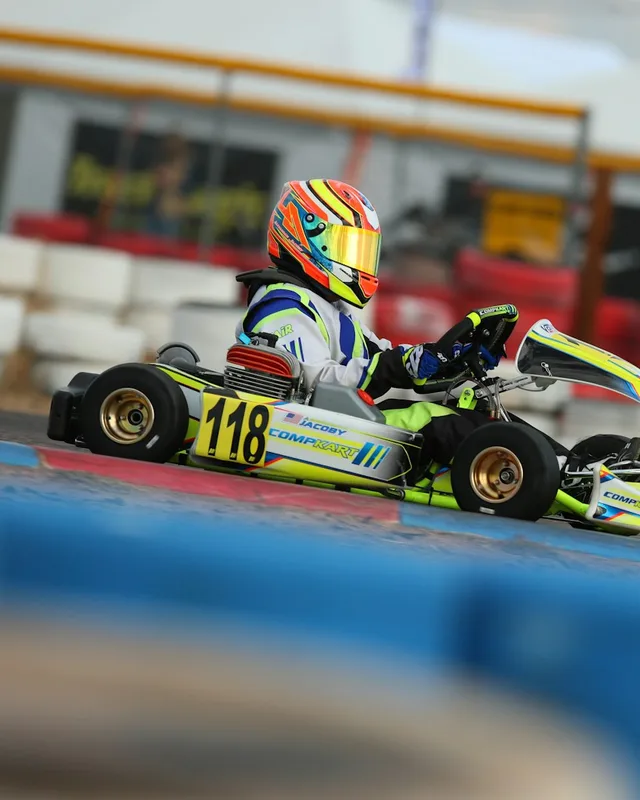 Piloto de kart com capacete colorido na pista
